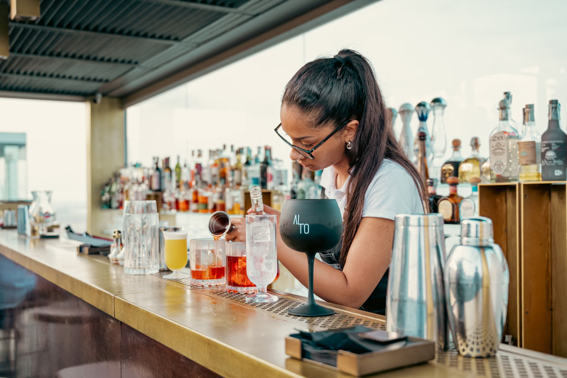 mixologist pouring cocktail rooftop